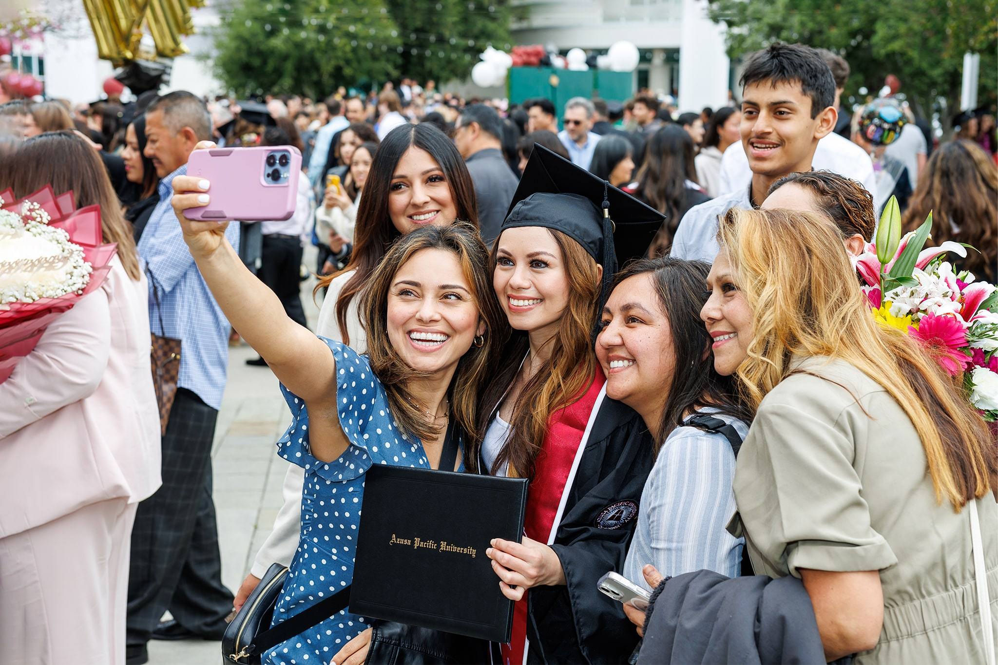 Image of Hispanic females taking a selfie at APU graduation
