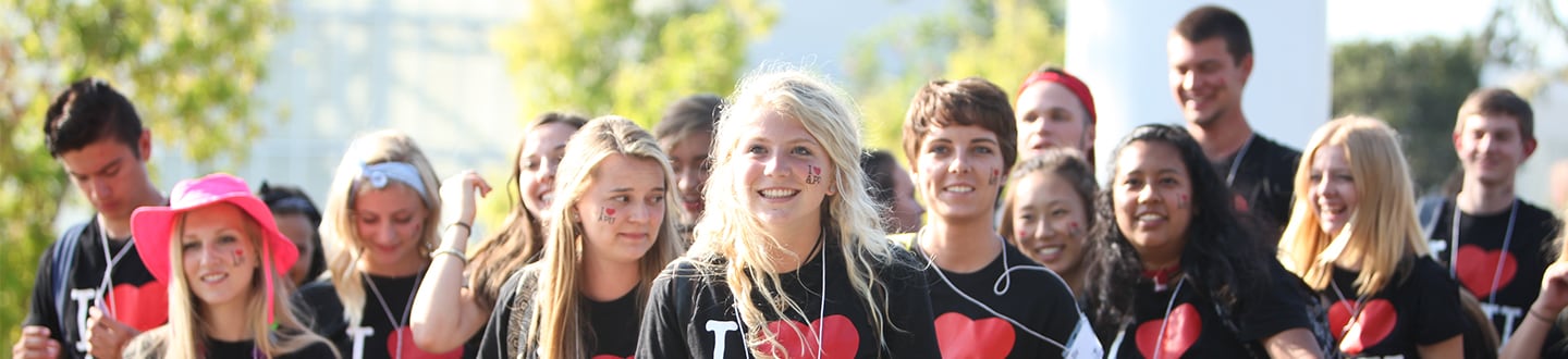 Student smiling in I Heart APU shirt