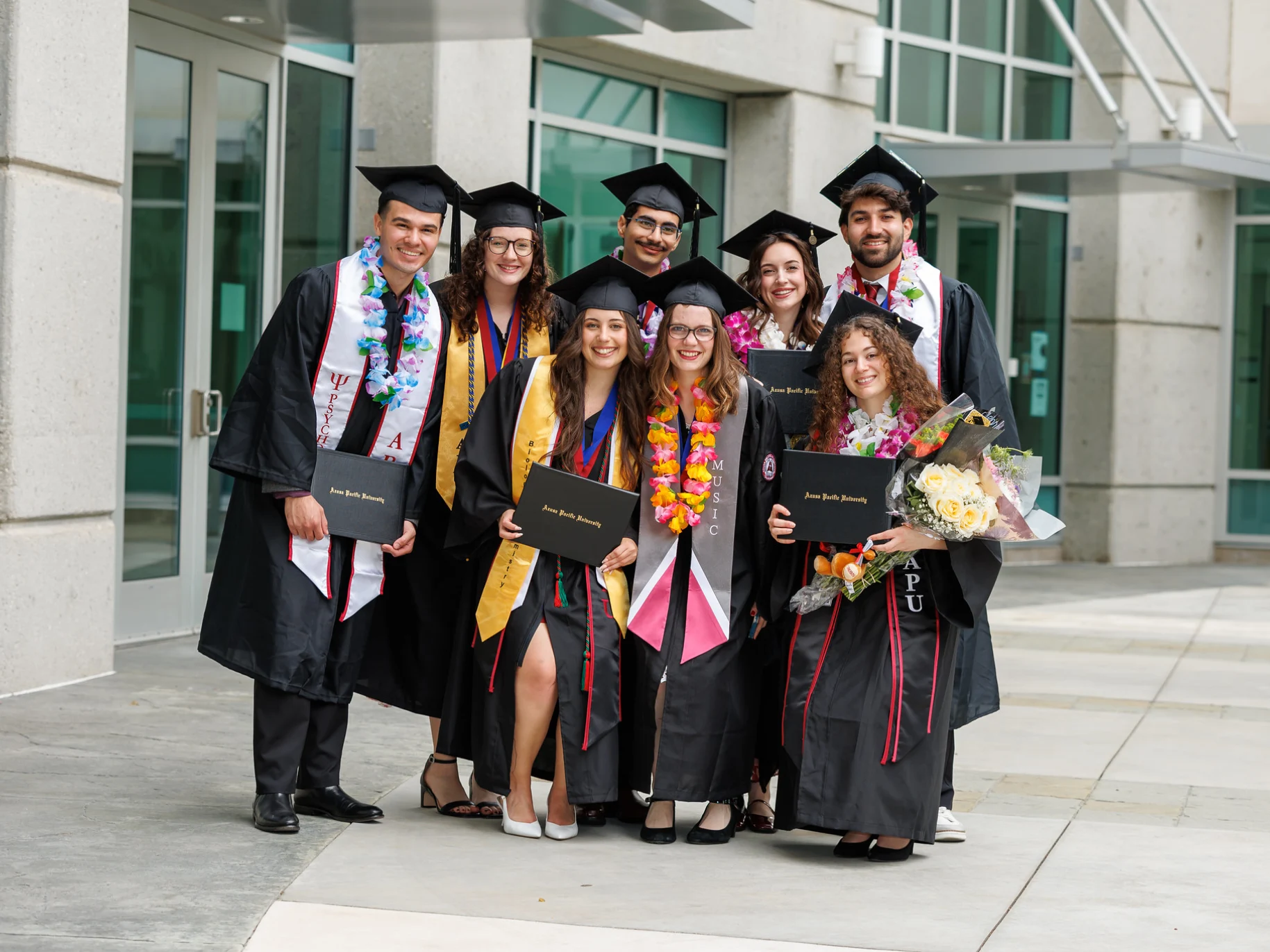 A group of students in regalia pose together at commencement