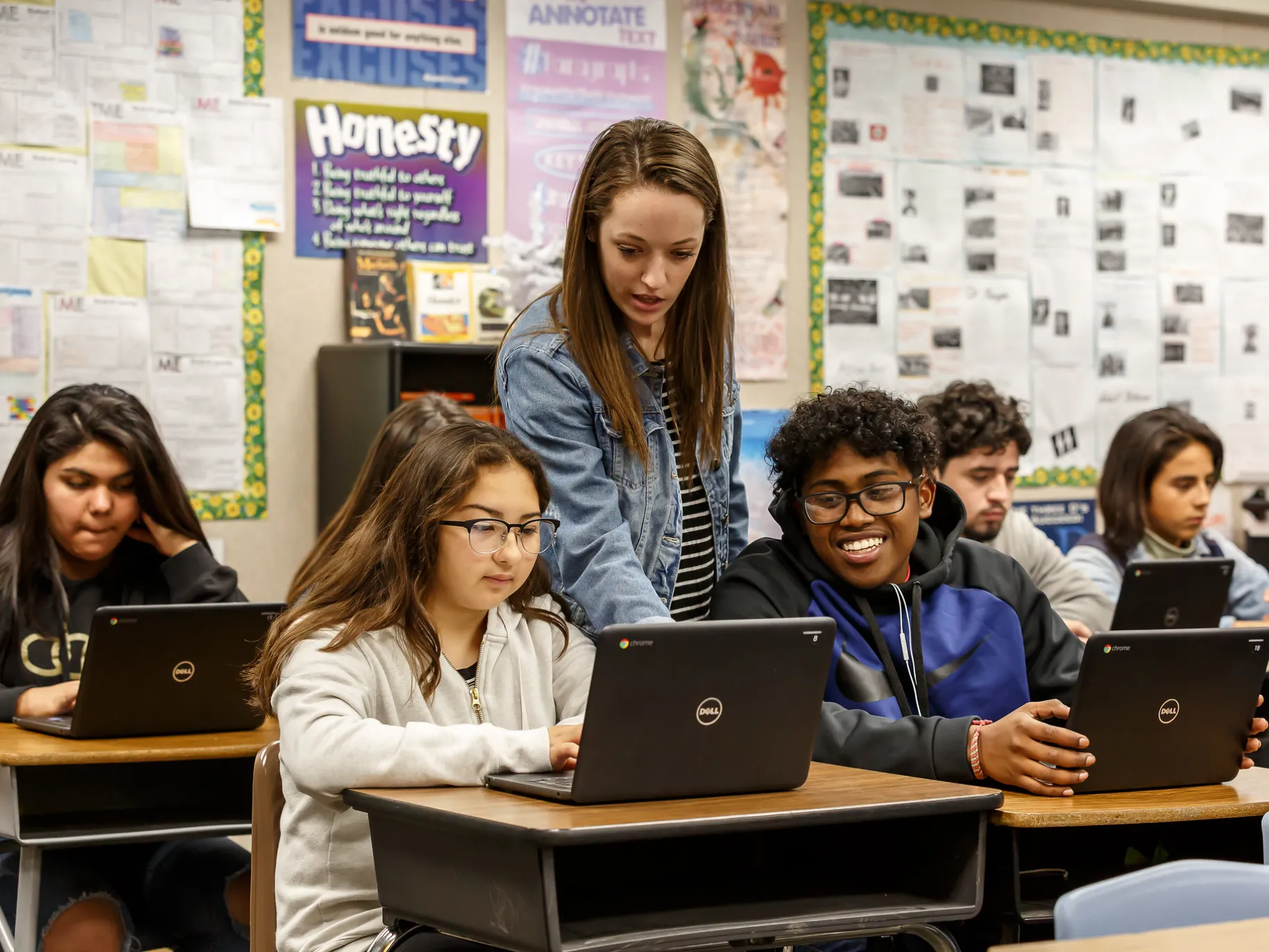A teacher works with two of her students.