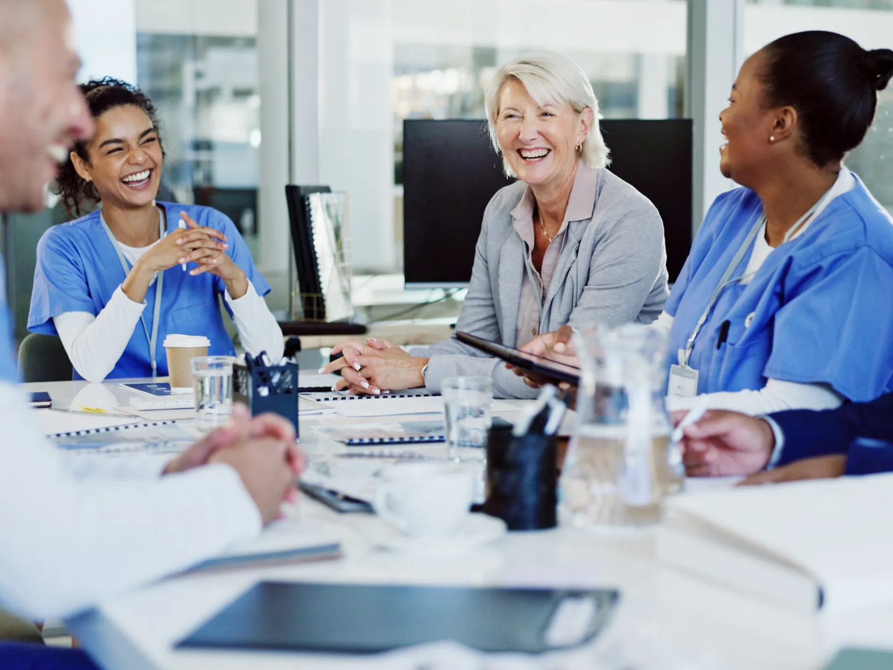 A team of healthcare workers collaborate on a case around a table.
