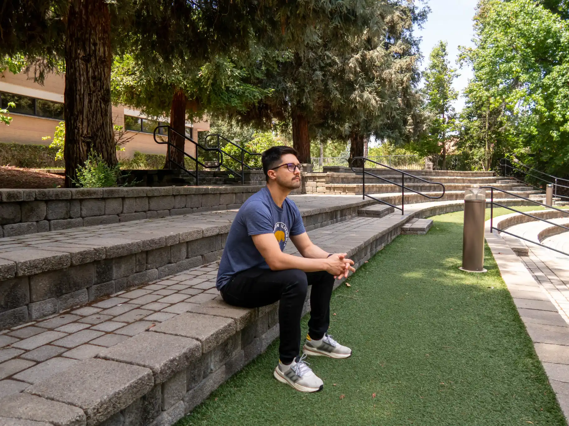 A student sits and prays on the steps of Wynn Amphitheater.