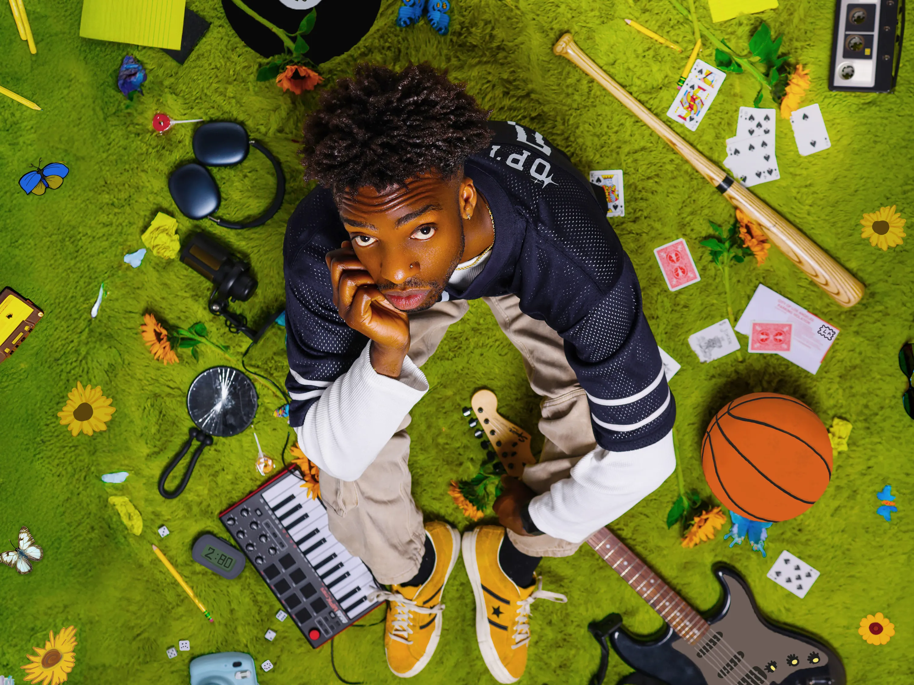 Jayo sits surrounded by various sports and music items