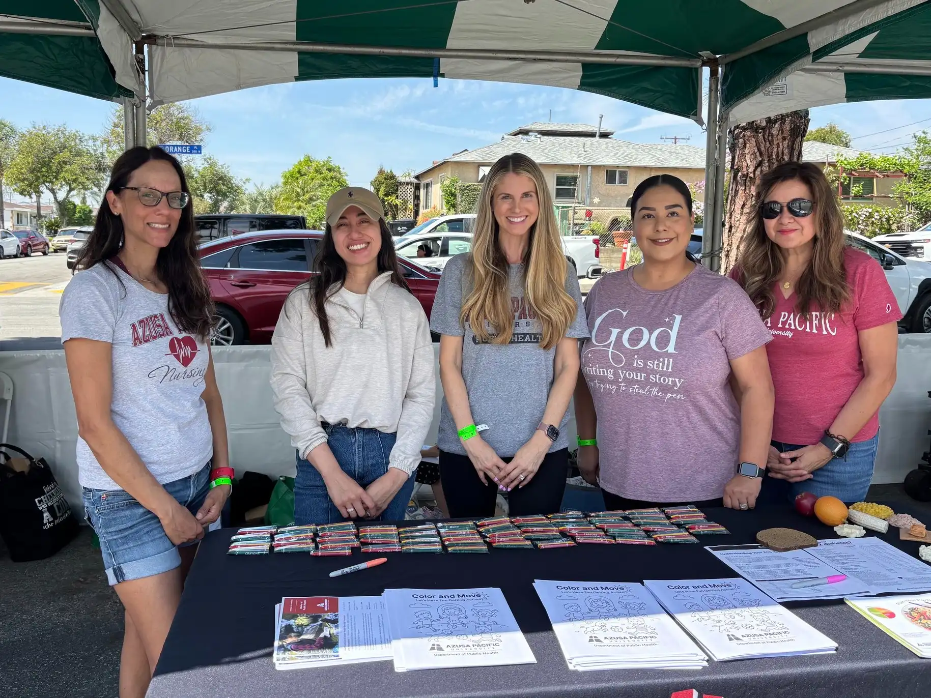 APU's public health students and faculty smile at an informational booth