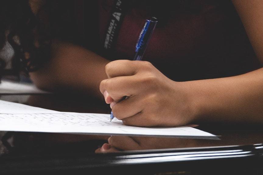 student writing on paper