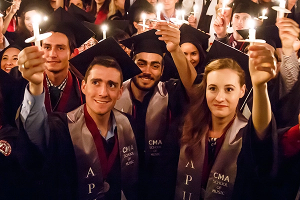 Image of students holding candles with youtube play button in center