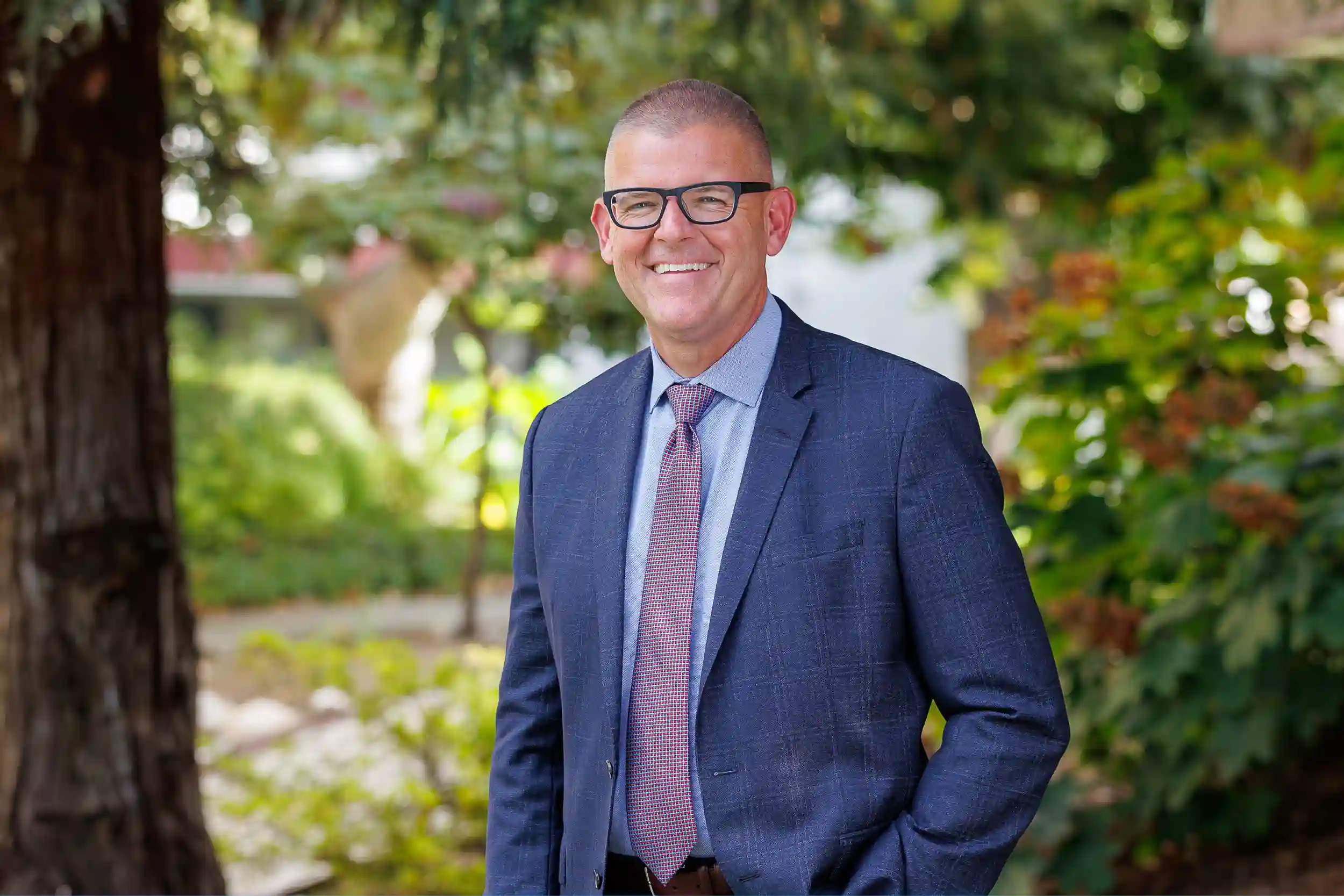president morris wearing a navy suit and smiling