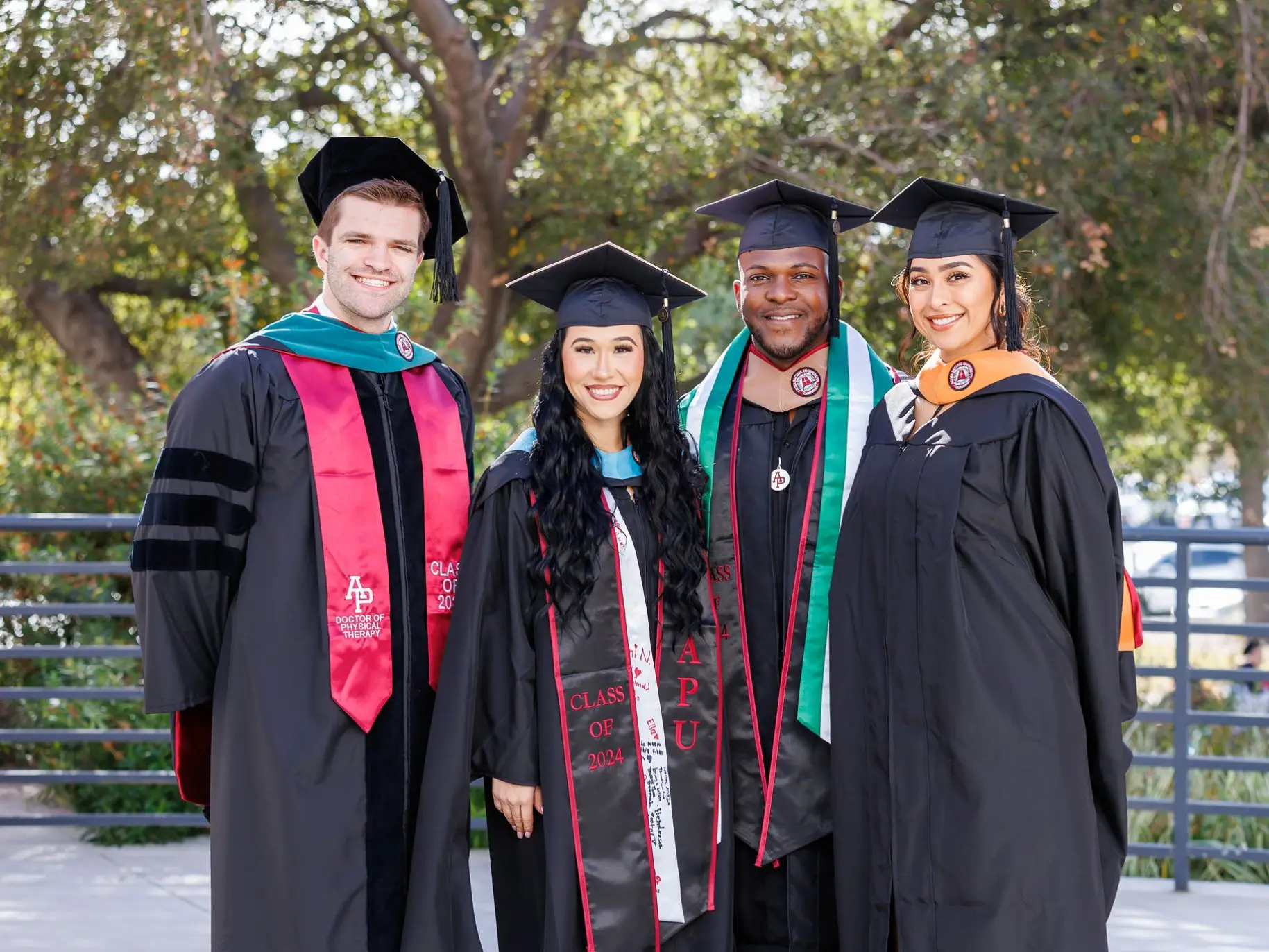 Four graduating students smile at commencement