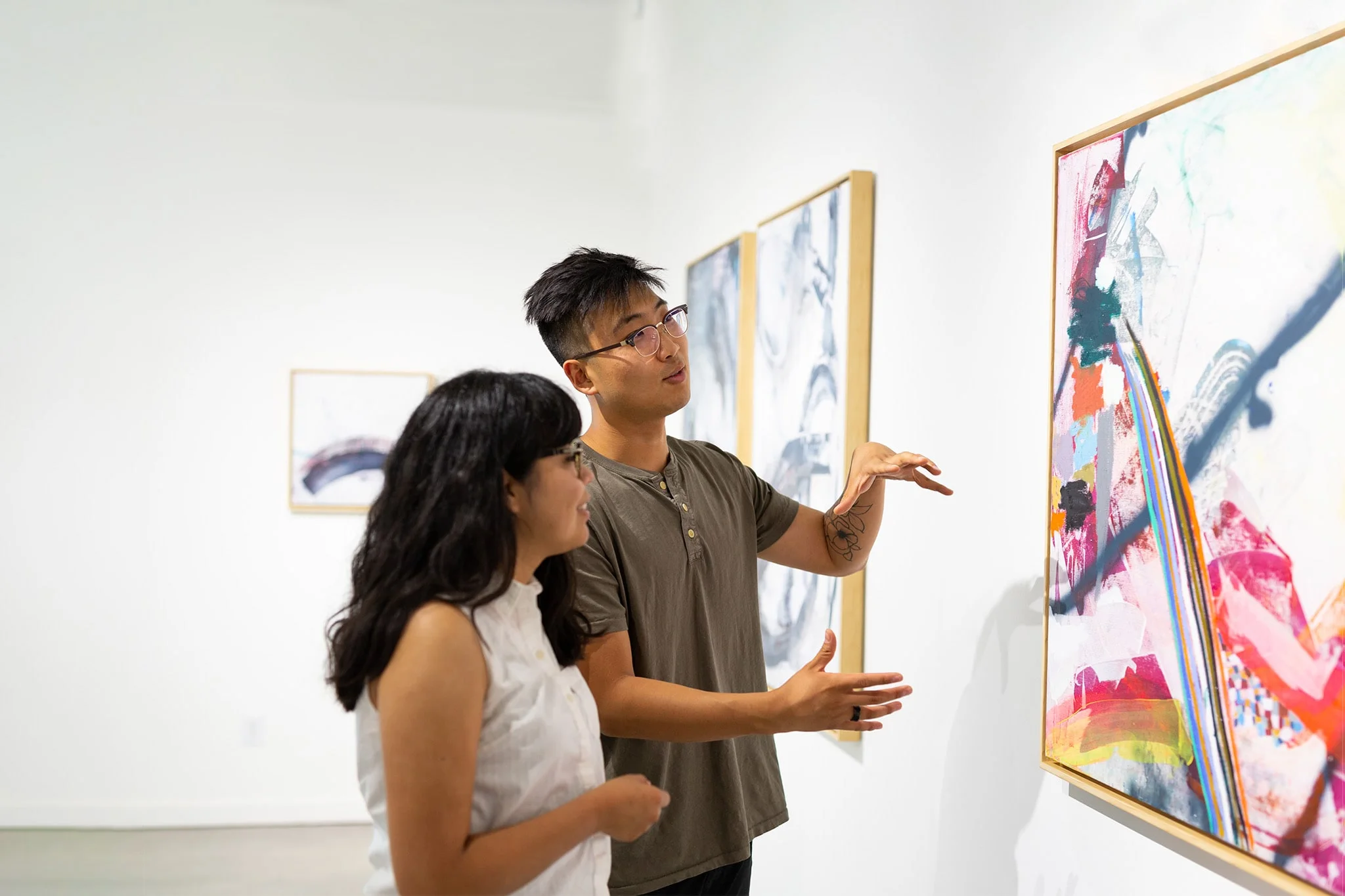 Two individuals looking at an abstract painting
