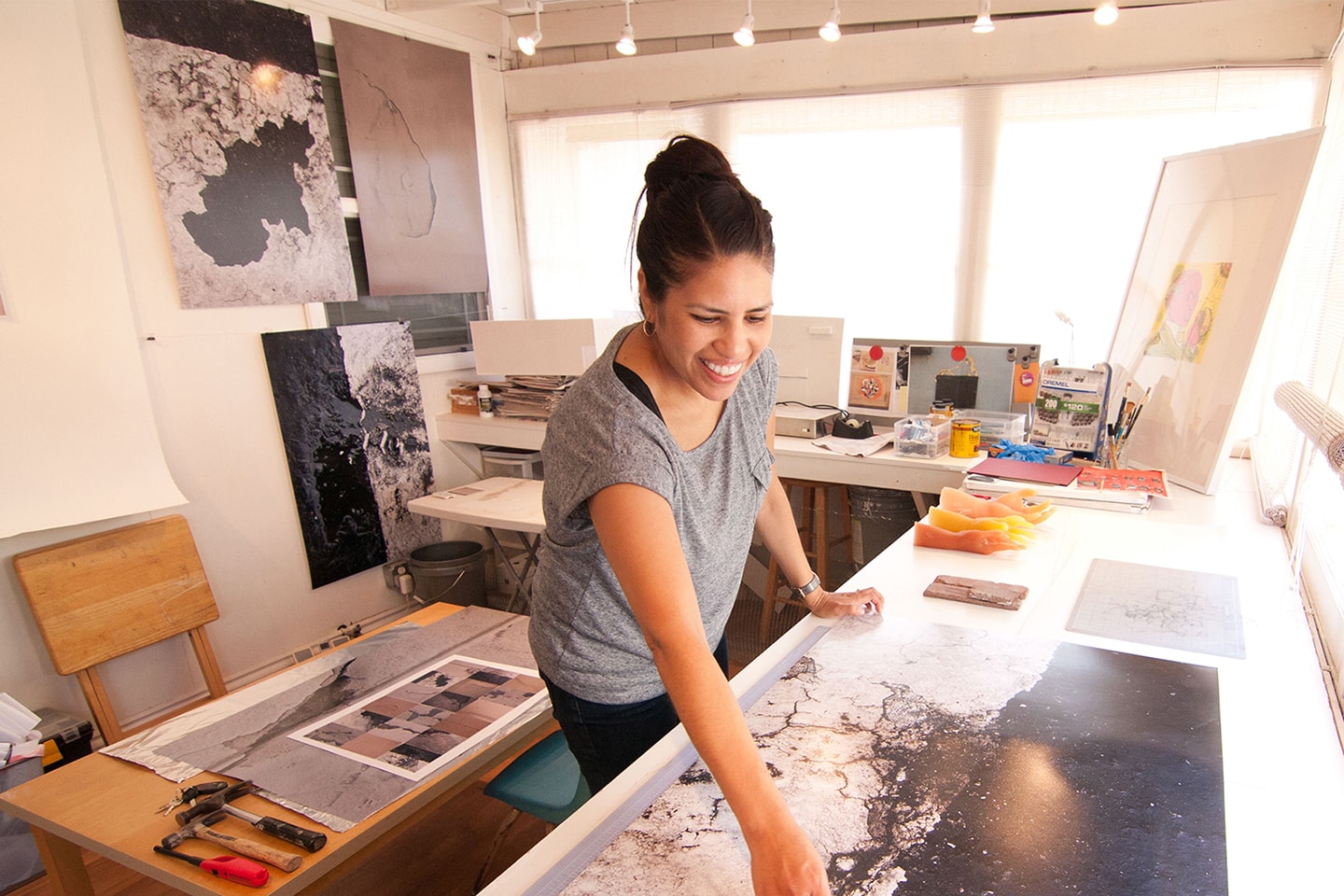 woman smiling while working on her art piece