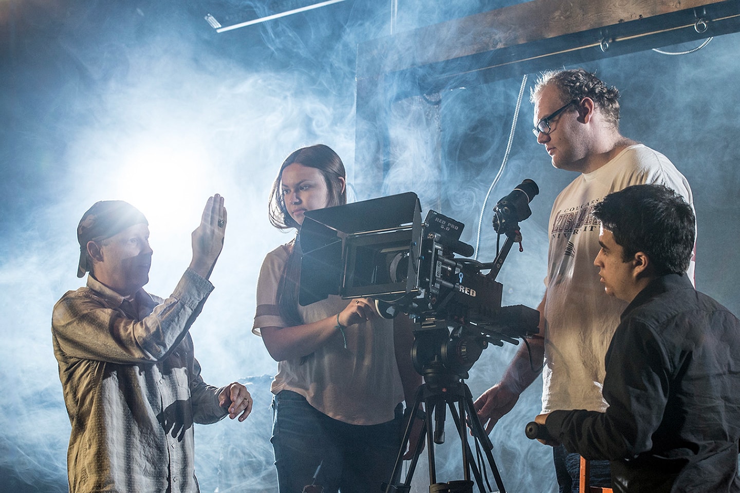 students learning from a professor how to use a camera