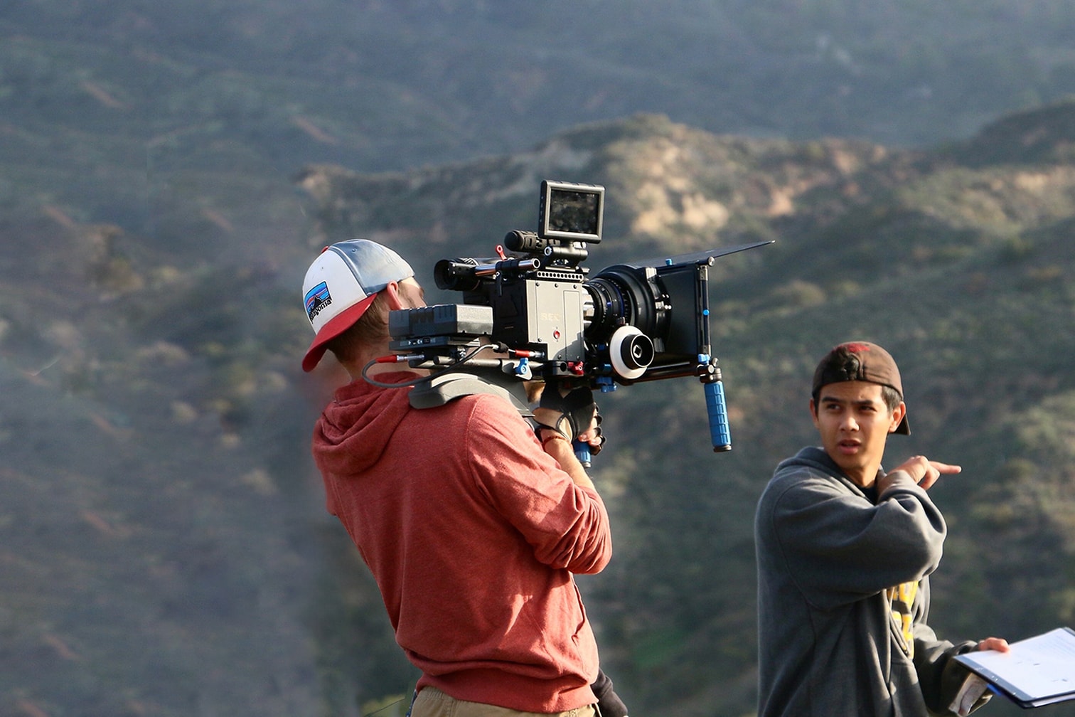 student holding a camera and recording his colleague