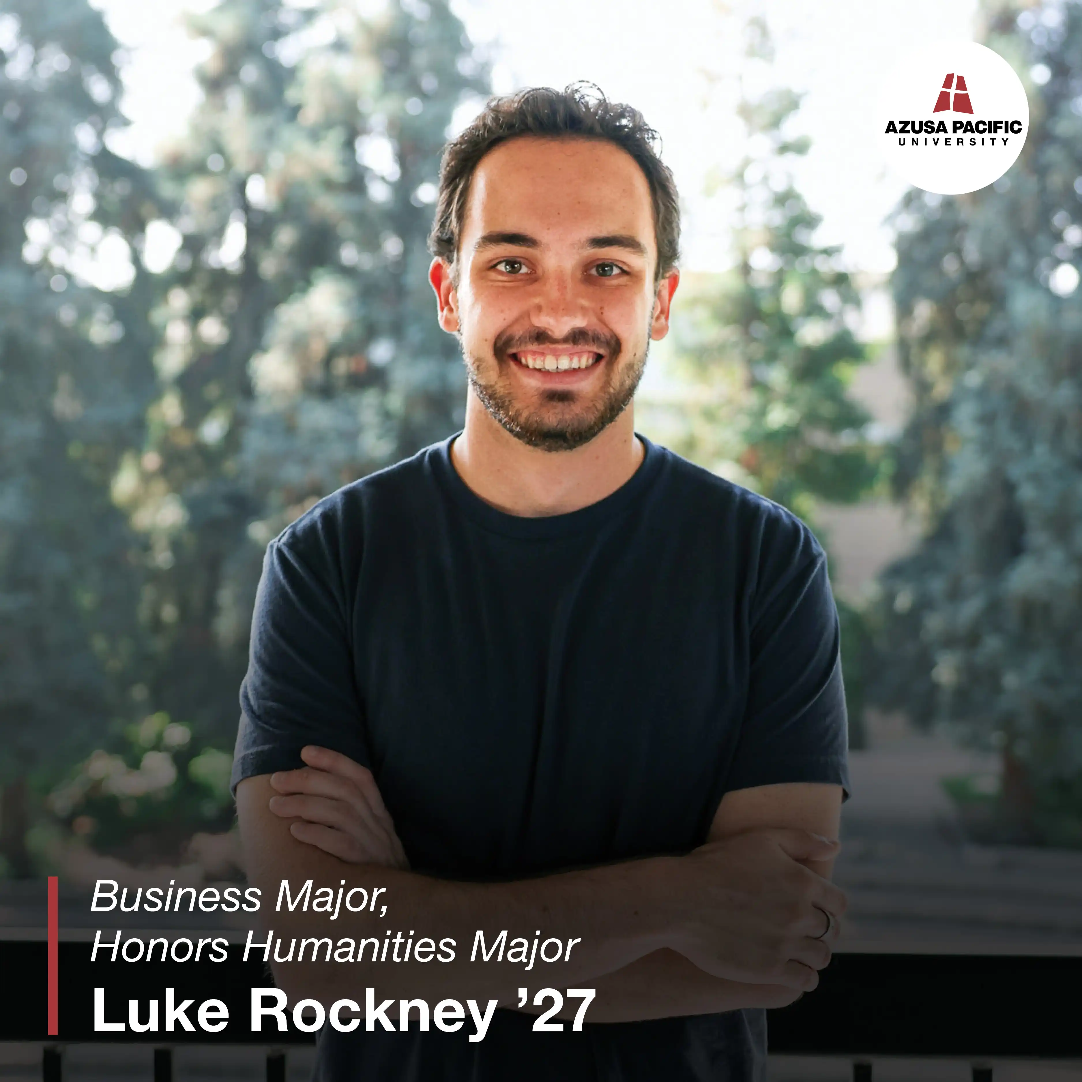 Luke smiling with his arms crossed