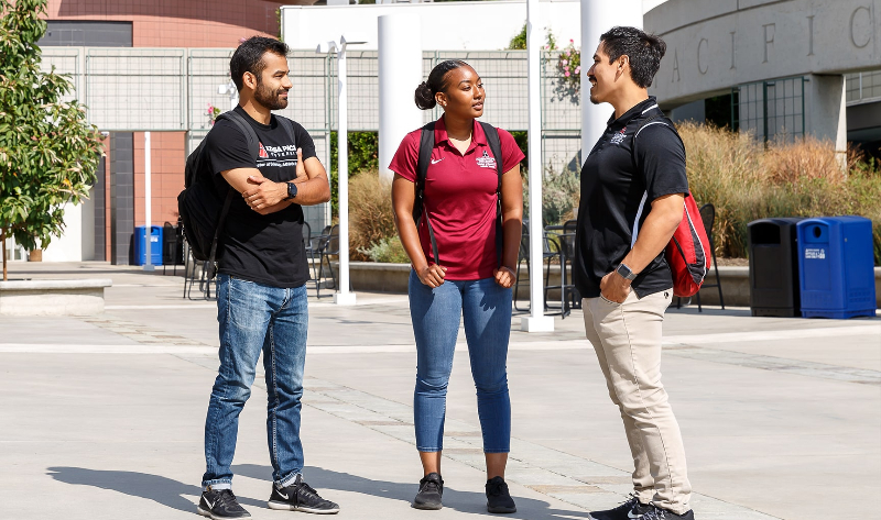 apu students talking and smiling on west campus